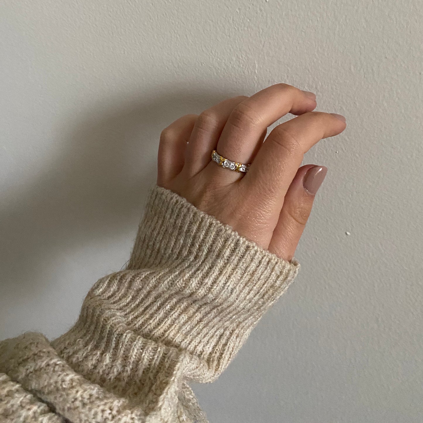 silver and gold ring intertwined with cubic zirconia stones